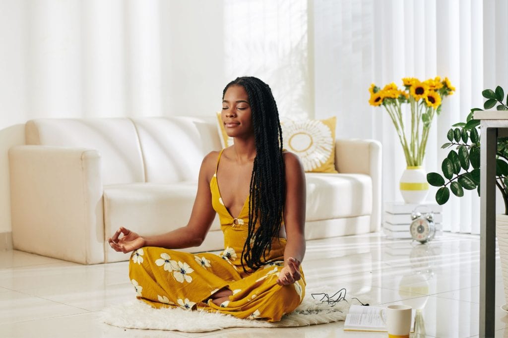 Woman sitting on floor meditating