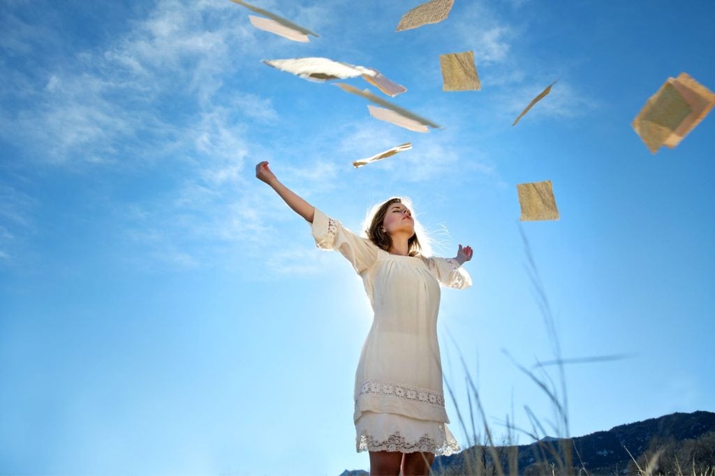 woman throwing papers in the air in freedom