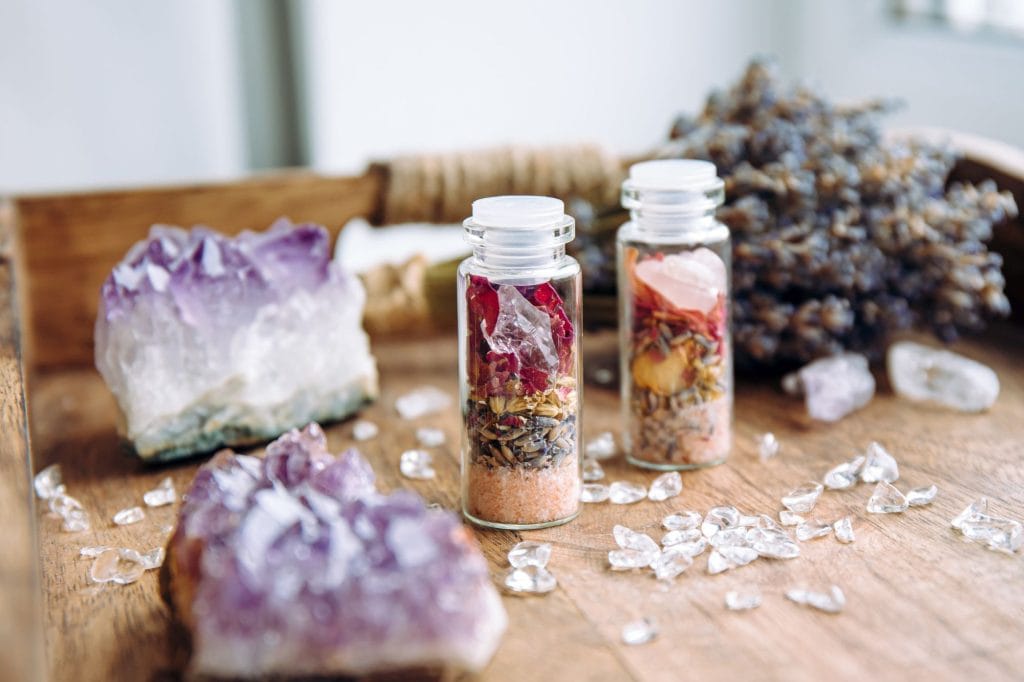 small manifestation jars filled with crystals and herbs