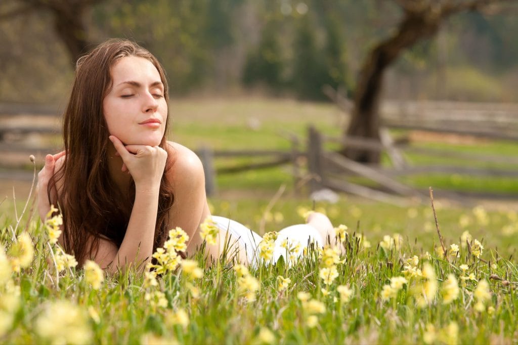woman thinking while lying on the grass