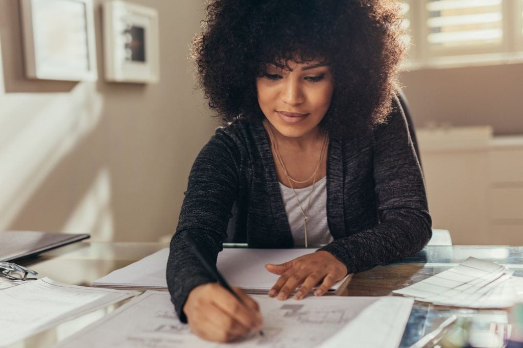 woman writing plans on a desk